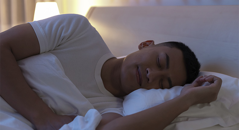 homem tendo uma ótima noite de sono em um ambiente com iluminação adequada