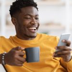 homem-sorrindo-usando-celular