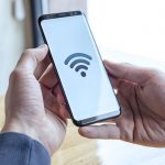 homem conectando o celular à rede wi-fi
