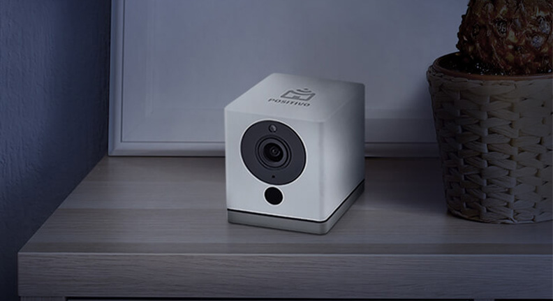 smart câmera da Positivo Casa Inteligente posicionada em cima de uma mesa