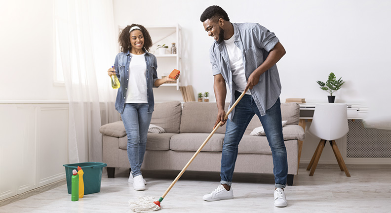 casal feliz limpando a casa com praticidade