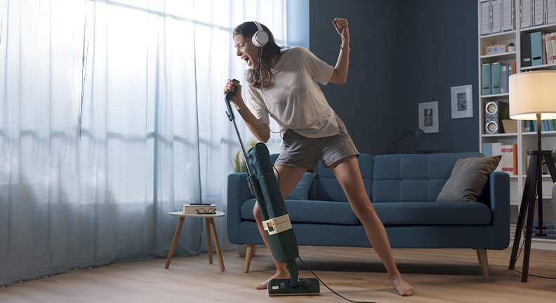 mulher limpando a casa com fones de ouvindo Bluetooth