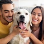 Casal abraçado com seu cachorro.