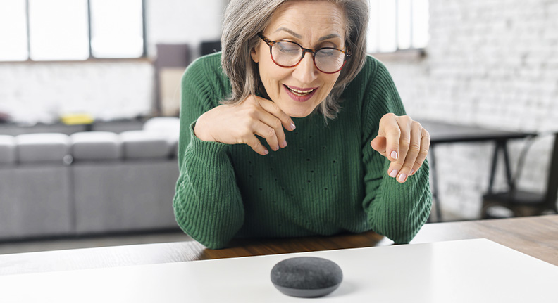 idosa usando um smart speaker para controlar seus dispositivos inteligentes
