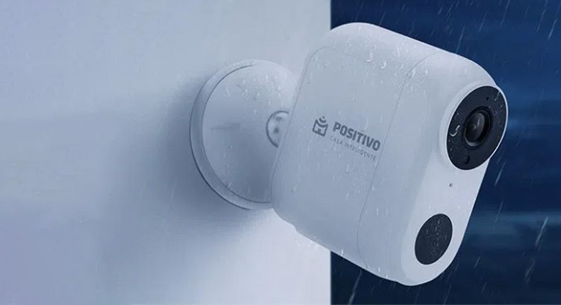 Smart Câmera Wi-Fi com Bateria da Positivo Casa Inteligente instalada em uma parede do lado de fora de uma casa tomando chuva