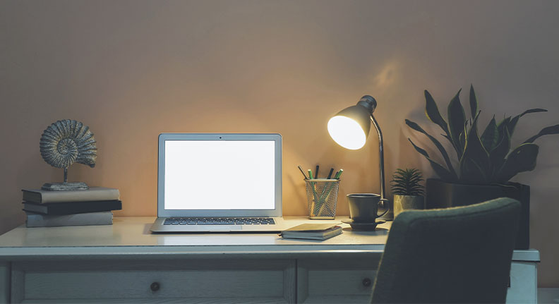 luminária de mesa com luz fria iluminando um home office