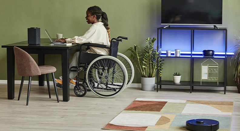 mulher na cadeira de rodas trabalhando em casa com vários dispositivos inteligentes
