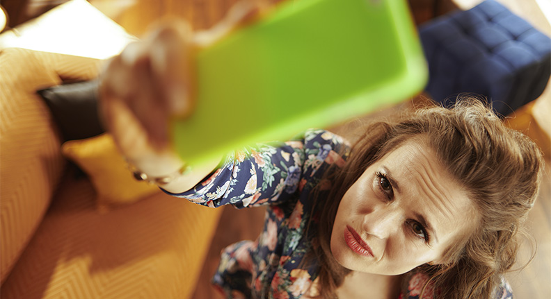 mulher com dificuldade de conectar seu celular ao wi-fi da casa