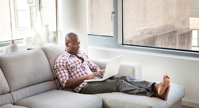homem usando o notebook na sala de casa com um ótima conexão wi-fi