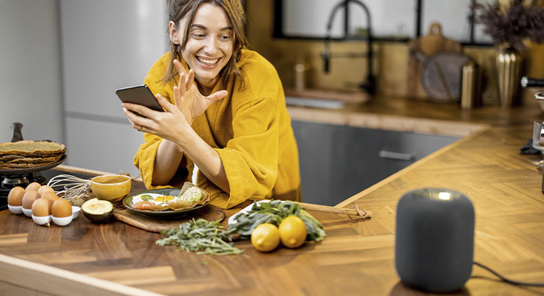 mulher usando uma Amazon Echo na cozinha