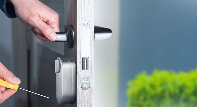 homem instalando uma smart fechadura wi-fi da Positivo Casa Inteligente na porta da frente de sua casa