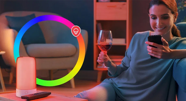 mulher sentada no chão da sala iluminada por uma Smart Luminária de Mesa Wi-fi da Positivo Casa Inteligente com luz colorida