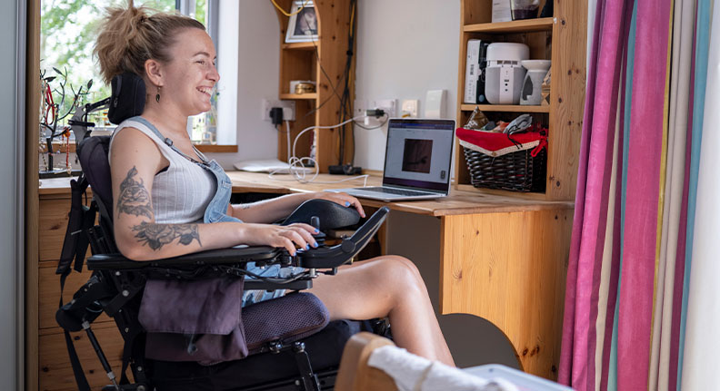 mulher em cadeira de rodas trabalhando em casa