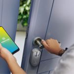 Mulher destrancando sua Smart Fechadura pelo celular.