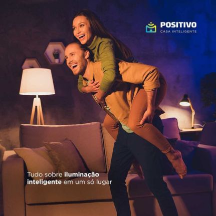 Casal curtindo um momento a dois sob a iluminação inteligente das smart lâmpadas da Positivo Casa Inteligente.
