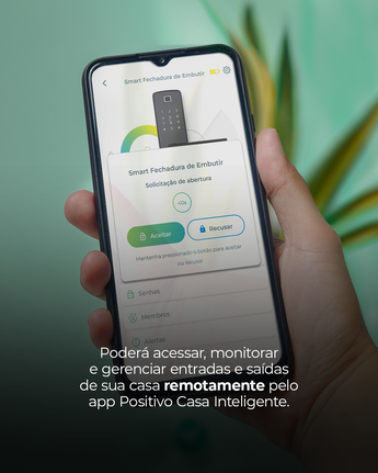 Pessoa segurando um celular com o app da Positivo Casa Inteligente aberto e abaixo há uma breve explicação de como controlar sua casa remotamente pelo app.