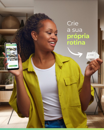 Mulher segurando um Smart Plug Wi-fi da Casa Inteligente e um celular com o app da marca aberto, programando sua rotina automatizada.