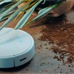 Smart Robô Aspirador da Positivo Casa Inteligente limpando a terra caída no chão.