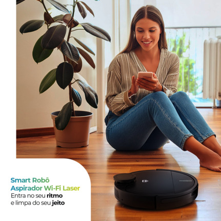 Mulher sentada no chão de sua casa controlando seu Smart Robô Aspirador Wi-fi Laser da Positivo Casa Inteligente pelo celular.